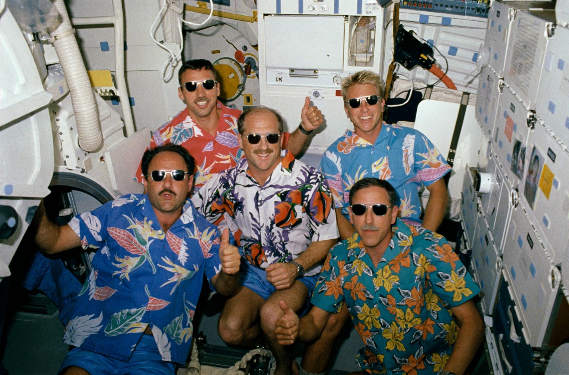 STS-26 crewmembers in Hawaiian shirts and sunglasses pose for group portrait